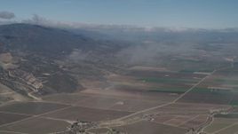 4K aerial stock footage Fly through a misty cloud and tilt to farm fields in Greenfield, California Aerial Stock Footage | AX70_246