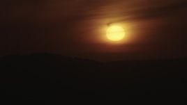 4K aerial stock footage of the sun setting behind hazy clouds and mountains in Southern California Aerial Stock Footage | AX70_282