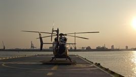 5.1K aerial stock footage of Patapsco River seen while lifting off from behind a helicopter on Pier 7, Maryland, sunset Aerial Stock Footage | AX73_147