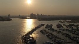 5.1K aerial stock footage flying over Baltimore Marine Center to approach Downtown Baltimore skyline at sunset, Maryland Aerial Stock Footage | AX73_148