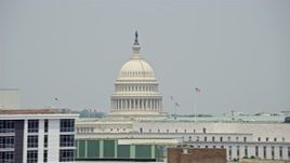 4.8K aerial stock footage of the United States Capitol Dome and flags seen from office buildings in Washington DC Aerial Stock Footage | AX74_091