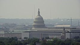 4.8K aerial stock footage of the United States Capitol dome behind Cannon House Offices and James Madison Building in Washington DC Aerial Stock Footage | AX75_056E