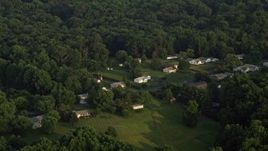 4.8K aerial stock footage flying by rural homes near forest, Manassas, Virginia, sunset Aerial Stock Footage | AX76_007E