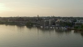 4.8K aerial stock footage approaching Ritz-Carlton Residences and Washington Harbour, by the Potomac River, in Georgetown, Washington D.C., sunset Aerial Stock Footage | AX76_053