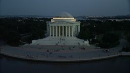 4.8K aerial stock footage of the Jefferson Memorial, lit up for the night, with tourists on the steps, Washington, D.C., twilight Aerial Stock Footage | AX76_184