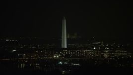 4.8K aerial stock footage of the Washington Monument behind office buildings in Washington, D.C., night Aerial Stock Footage | AX77_035E