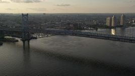 4.8K aerial stock footage approaching Benjamin Franklin Bridge spanning the Delaware River, Philadelphia, Sunset Aerial Stock Footage | AX80_002E