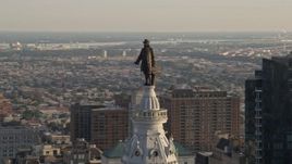4.8K aerial stock footage approaching the William Penn statue atop Philadelphia City Hall, Pennsylvania, Sunset Aerial Stock Footage | AX80_034