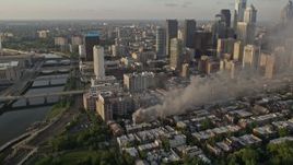 4.8K aerial stock footage of residential fire by the Downtown Philadelphia skyline, Pennsylvania, Sunset Aerial Stock Footage | AX80_042