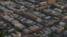 4.8K aerial stock footage flying by row houses in North Philadelphia, Pennsylvania, Sunset Aerial Stock Footage | AX80_052