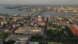 4.8K aerial stock footage flying over office buildings and by Benjamin Franklin Bridge, Philadelphia, Pennsylvania, Sunset Aerial Stock Footage | AX80_059