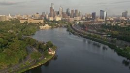 4.8K aerial stock footage of Downtown Philadelphia skyline seen from Boathouse Row and the the Schuylkill River, Pennsylvania, Sunset Aerial Stock Footage | AX80_065E