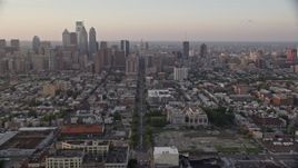4.8K aerial stock footage tilting from Broad Street and urban South Philly neighborhood to reveal and approach Downtown Philadelphia skyline, Pennsylvania, Sunset Aerial Stock Footage | AX80_112E