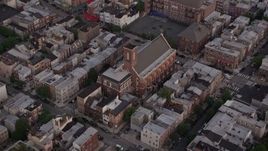 4.8K aerial stock footage of Saint Paul Church in an urban neighborhood, South Philadelphia, Pennsylvania, Sunset Aerial Stock Footage | AX80_158