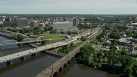 4.8K aerial stock footage approach and orbit bridges spanning the Delaware River, reveal commuter train and courthouse, Trenton, New Jersey Aerial Stock Footage | AX82_067E