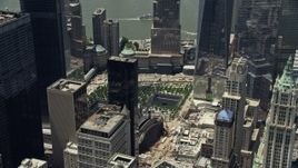 4.8K aerial stock footage of World Trade Center Memorial, tilt to reveal One World Trade Center, Lower Manhattan, New York City Aerial Stock Footage | AX83_164