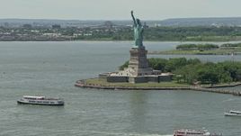 4.8K aerial stock footage of Statue of Liberty and passing ferries in New York Harbor, New York City Aerial Stock Footage | AX83_191E