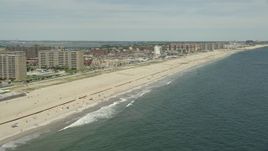 4.8K aerial stock footage of beachfront apartment complexes and sunbathers at Rockaway Beach, New York Aerial Stock Footage | AX83_228