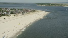 4.8K aerial stock footage of a small group of people on the beach near beachfront homes, Point Lookout, New York Aerial Stock Footage | AX83_248