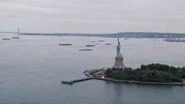 4K aerial stock footage Flying by Statue of Liberty, reveal Verranzano-Narrows Bridge, New York, New York Aerial Stock Footage | AX84_008