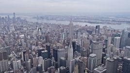 4K aerial stock footage of tilt from Midtown buildings to reveal and approach Chrysler Building, Empire State Building, New York City Aerial Stock Footage | AX84_070E
