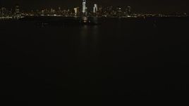 4K aerial stock footage Revealing Statue of Liberty, Lower Manhattan skyline, New York, New York, night Aerial Stock Footage | AX85_002