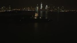 4K aerial stock footage Revealing Statue of Liberty, Lower Manhattan skyline, New York, New York, night Aerial Stock Footage | AX85_003