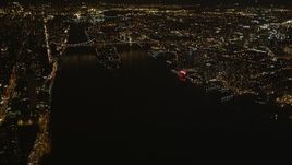 4K aerial stock footage Tilt up from East River, revealing Queensboro Bridge, New York, New York, night Aerial Stock Footage | AX85_060