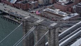 4K aerial stock footage of an American flag atop the Brooklyn Bridge, New York City Aerial Stock Footage | AX86_026