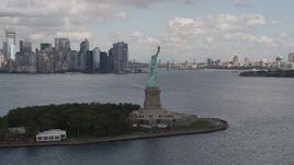 4K aerial stock footage Back of the Statue of Liberty, reveal Lower Manhattan skyline, New York, New York Aerial Stock Footage | AX87_012