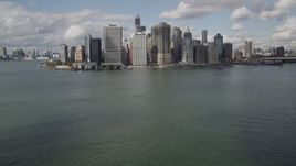 4K aerial stock footage Tilt up from bay to reveal Lower Manhattan skyscrapers, New York, New York Aerial Stock Footage | AX87_046