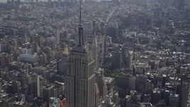 4K aerial stock footage Flying by the top of the Empire State Building, Midtown Manhattan, New York Aerial Stock Footage | AX87_105