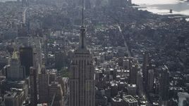 4K aerial stock footage Tilting down while flying by Empire State Building, Midtown Manhattan, New York Aerial Stock Footage | AX87_106