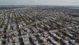 4K aerial stock footage of flying over row houses, tilt to railroad tracks, Brooklyn, New York Aerial Stock Footage | AX88_033