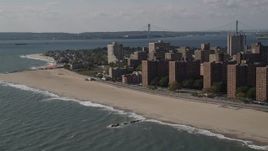 4K aerial stock footage of flying by Coney Island Beach, with a view of the Verrazano-Narrows Bridge, Brooklyn, New York Aerial Stock Footage | AX88_052