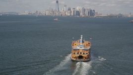 4K aerial stock footage of a Staten Island Ferry sailing New York Harbor and Lower Manhattan skyline, New York Aerial Stock Footage | AX88_094