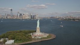4K aerial stock footage of flying by Statue of Liberty, with views of Lower Manhattan skyline and Brooklyn, New York Aerial Stock Footage | AX88_110