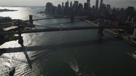 4K aerial stock footage tilt from East River, reveal Brooklyn Bridge, Manhattan Bridge, and Lower Manhattan skyscrapers, New York Aerial Stock Footage | AX88_124