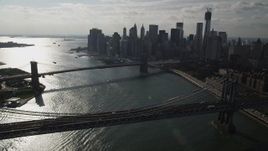 4K aerial stock footage fly over Manhattan Bridge, approach Brooklyn Bridge and Lower Manhattan skyscrapers, New York Aerial Stock Footage | AX88_125