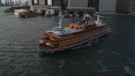 4K aerial stock footage of orbiting the Staten Island Ferry leaving the Lower Manhattan terminal, New York Aerial Stock Footage | AX88_162