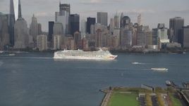 4K aerial stock footage of a cruise ship passing Lower Manhattan skyline, New York Aerial Stock Footage | AX88_174