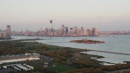4K aerial stock footage Approaching Ellis Island, Lower Manhattan skyline, New York, New York, sunset Aerial Stock Footage | AX89_001