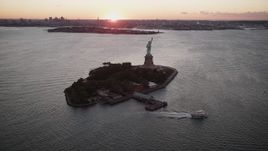 4K aerial stock footage Flying by Statue of Liberty, Liberty Island, New York Harbor, New York, sunrise Aerial Stock Footage | AX90_001