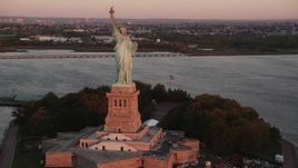 4K aerial stock footage Flying by Statue of Liberty, Liberty Island, New York, New York, sunrise Aerial Stock Footage | AX90_015