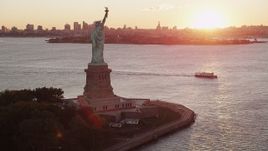 4K aerial stock footage Flying by Statue of Liberty, Brooklyn in the distance, New York, New York, sunrise Aerial Stock Footage | AX90_018