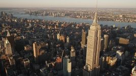 Flying by Empire State Building, Midtown Manhattan, New York, sunrise Aerial Stock Footage | AX90_057