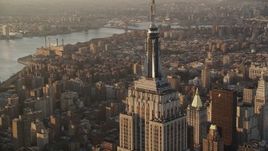 Flying by Empire State Building, Midtown Manhattan, New York, sunrise Aerial Stock Footage | AX90_061