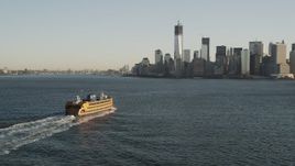 4K aerial stock footage Flying by Staten Island Ferry, approaching Lower Manhattan, New York, sunrise Aerial Stock Footage | AX90_129