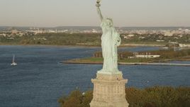 4K aerial stock footage Flying by Statue of Liberty, Liberty Island, New York Harbor, New York, sunrise Aerial Stock Footage | AX90_140