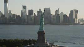 4K aerial stock footage Flying by Statue of Liberty, Lower Manhattan, New York, New York, sunrise Aerial Stock Footage | AX90_147